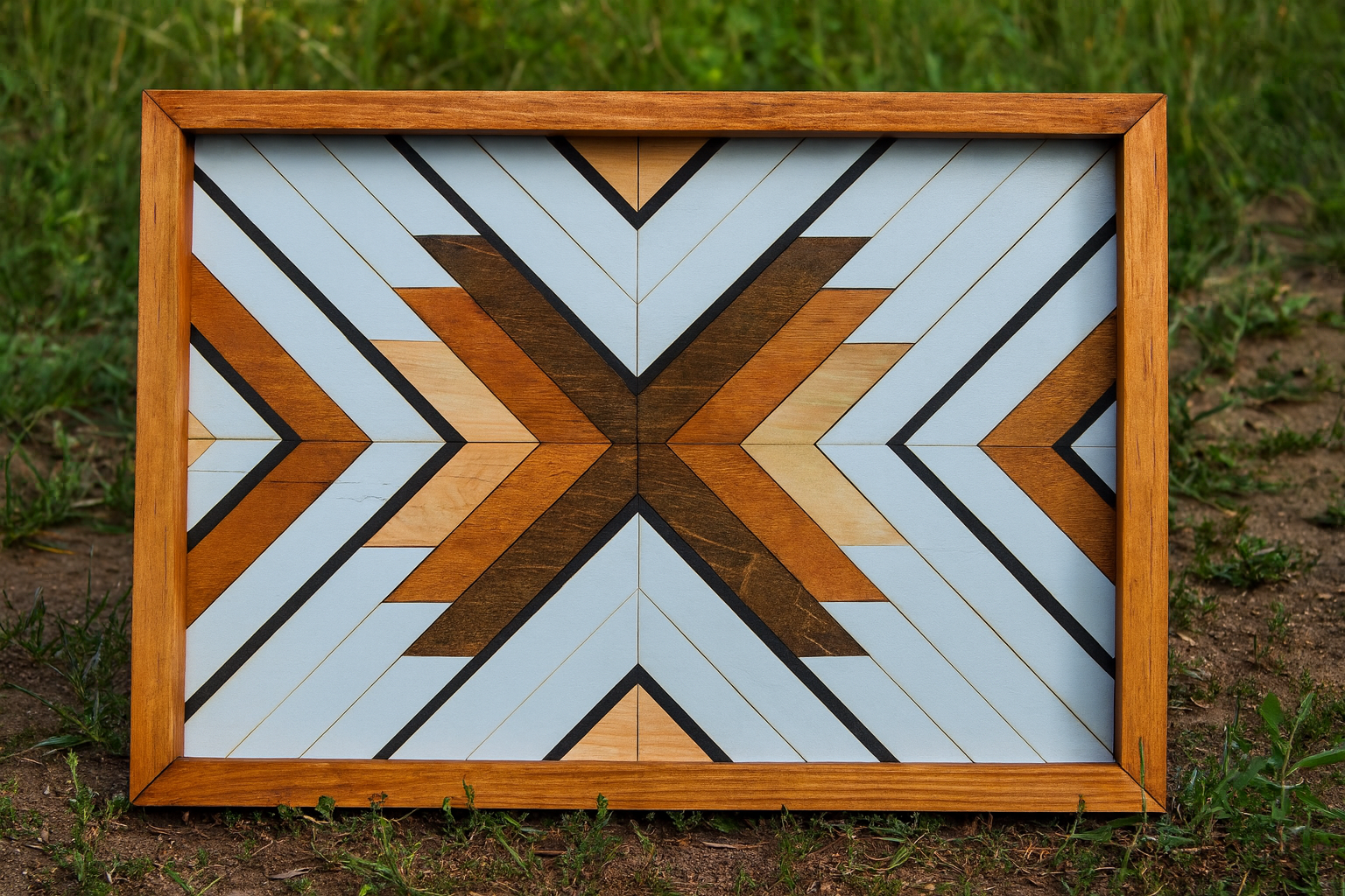 Framed geometric wood art piece with wooden frame on grass