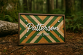 Wooden nameplate with geometric design and 'Patterson est. 2021' text, set against a forest background.
