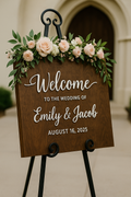 Wedding welcome sign with floral decorations in front of a building entrance